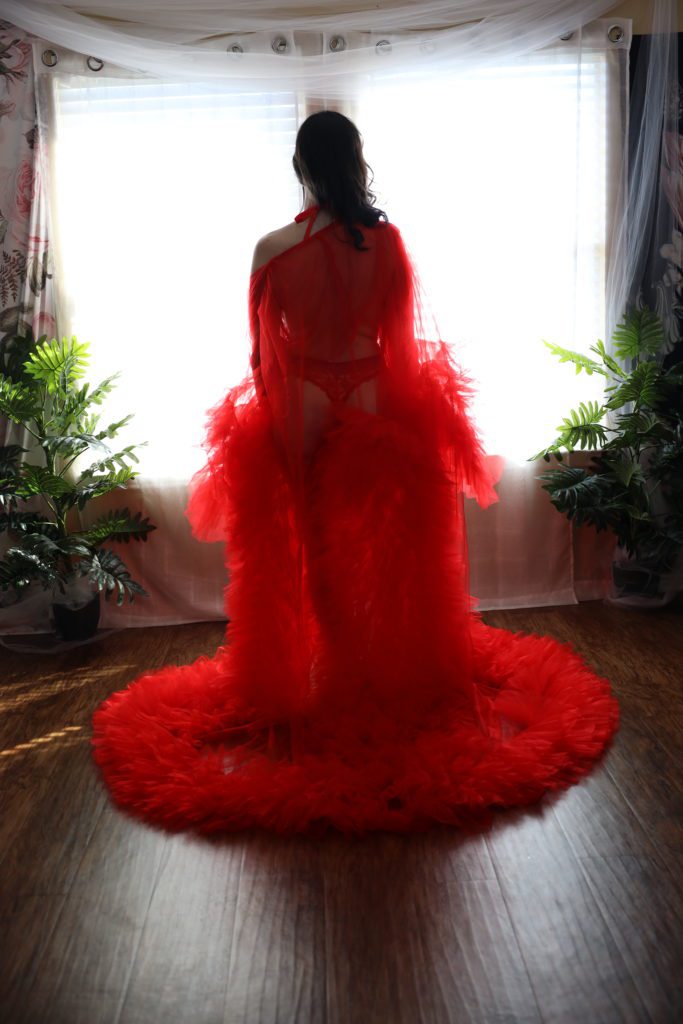 portrait of model in red luxe robe in boudoir studio